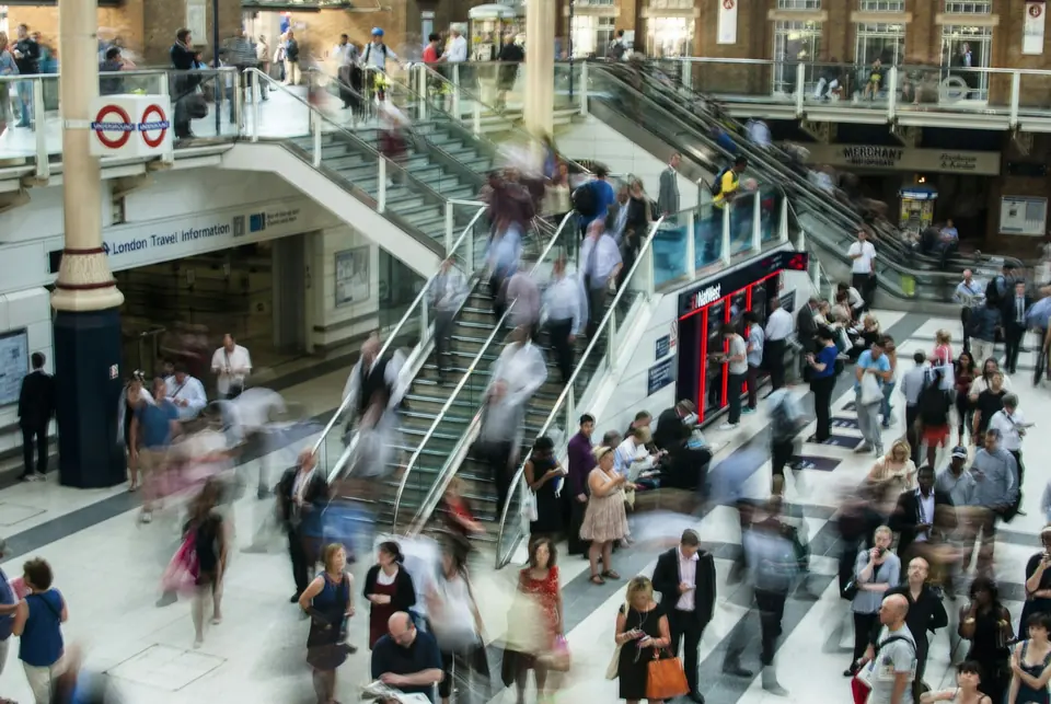 Pendlere i bevegelse på rulletrapper og i hallen på Liverpool Street stasjon i London