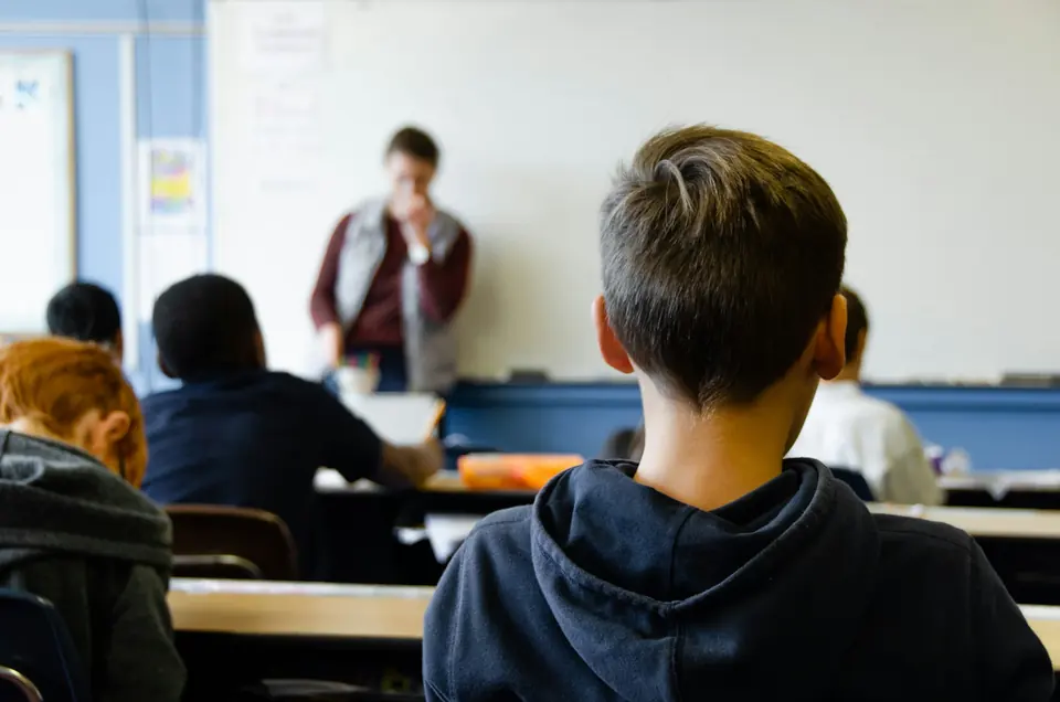 Elev i klasserom sett bakfra mens læreren underviser